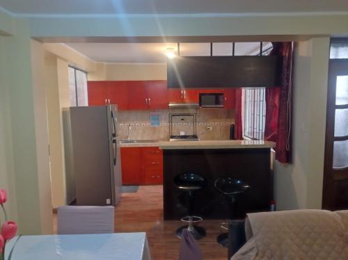 een keuken met een roestvrijstalen koelkast en rode kasten bij Oceánica Lodge in Ilo