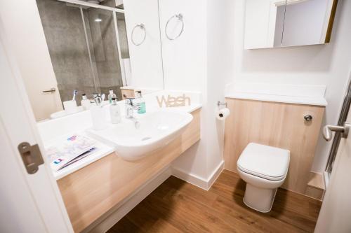 a bathroom with a white sink and a toilet at Riverside House at Guildford in Guildford