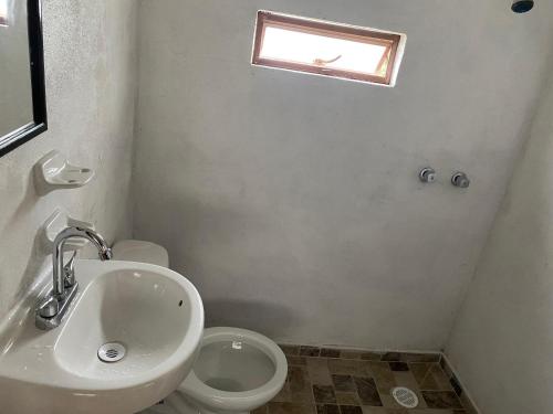 a bathroom with a sink and a toilet and a window at Villa Sofia in Tlatlauquitepec