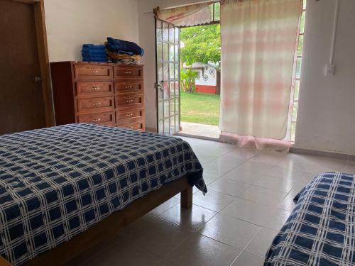 a bedroom with a bed and a dresser and a window at Villa Sofia in Tlatlauquitepec