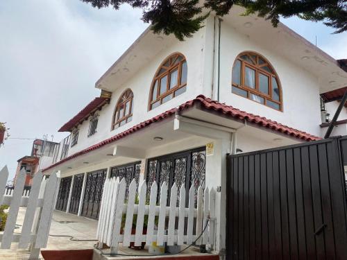 a white house with a fence in front of it at Villa Sofia in Tlatlauquitepec