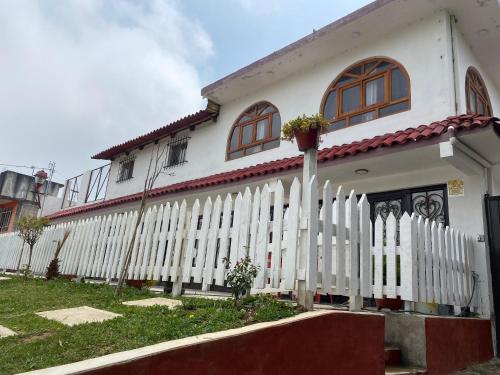 a white house with a fence in front of it at Villa Sofia in Tlatlauquitepec