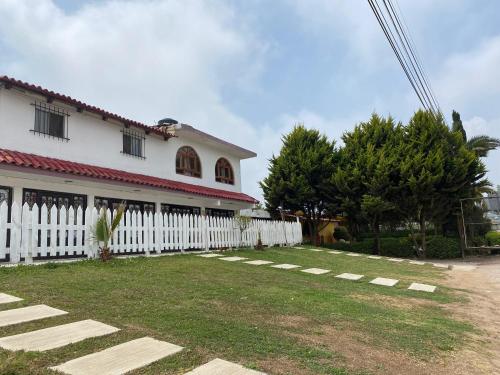 a white house with a white picket fence at Villa Sofia in Tlatlauquitepec