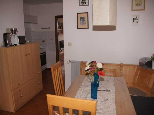 a kitchen with a table with a vase of flowers on it at Holiday apartment with 2 bedrooms in Zirkitz