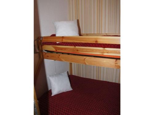 1-bedroom holiday apartment في Zirkitz: سريرين بطابقين في غرفة صغيرة مع مقعد