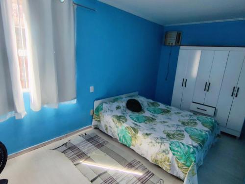 a blue room with a bed in a bedroom at Apto pé na Areia 2 in Ilha do Frade