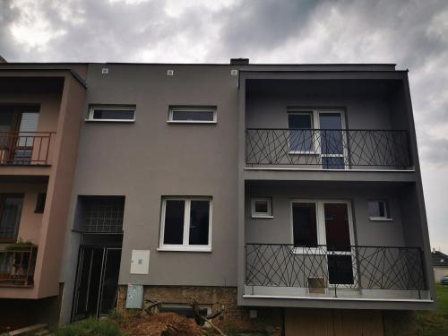 a gray building with windows and a balcony at Vinobike Morava Gold Residence in Moravská Nová Ves
