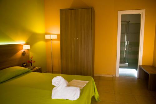 een hotelkamer met een bed met handdoeken erop bij B&B Liberty in Messina