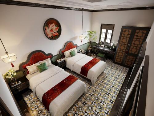a bedroom with two beds and a living room at C'Lau Hotel Ninh Binh in Ninh Binh