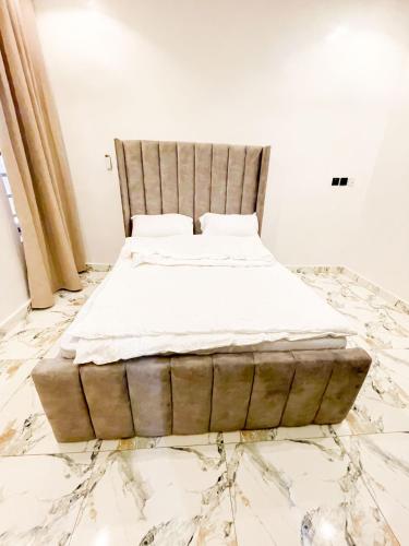 a bed sitting on top of a marble floor at Nova Rise Apartment - Large 3BR with Wifi PS5 247 Power Smart TV in Lekki