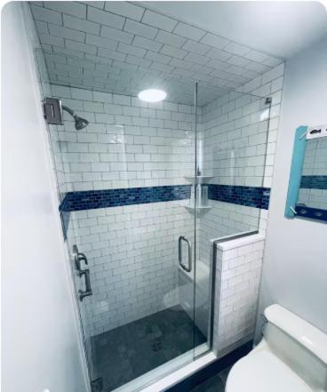 a bathroom with a glass shower with a toilet at Dog-Friendly Oceanfront Getaway - Walk to Dining - Private Beach Access in Milford