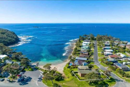 an aerial view of a beach with houses and the ocean at Grand Spindrift - Entire Waterfront House in Malua Bay