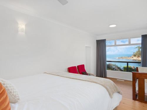 a bedroom with a bed with a view of the ocean at Oceanfront Beauty in Lilli Pilli in Surf Beach