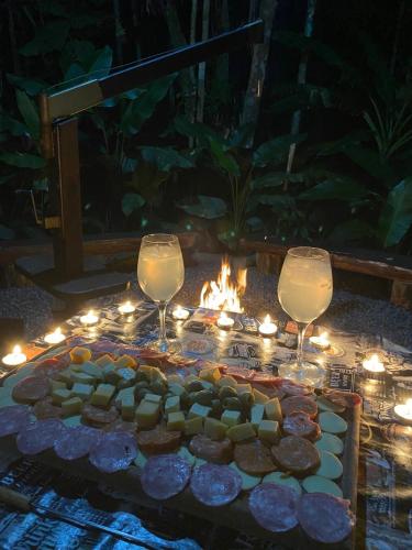 a table with two wine glasses and a tray of food at Ada Verde in Rio dos Cedros