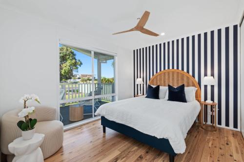 a bedroom with a bed and a balcony at Pat's Place in Tomakin
