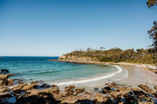 Una vista de una playa con rocas y el océano. en Two Salty Dogs, en Surf Beach