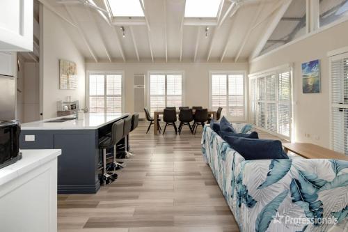 Una cocina y una sala de estar con un sofá y una mesa. en Two Salty Dogs, en Surf Beach