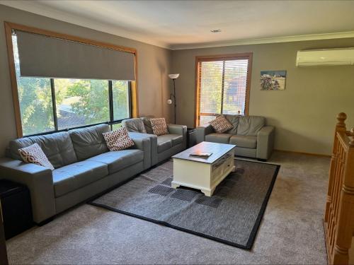 a living room with a couch and a coffee table at High Tide - Minutes from Lilli Pilli Beach in Surf Beach