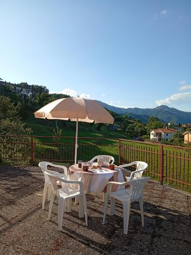 a white table and chairs with an umbrella at Sunflower in Tavarone