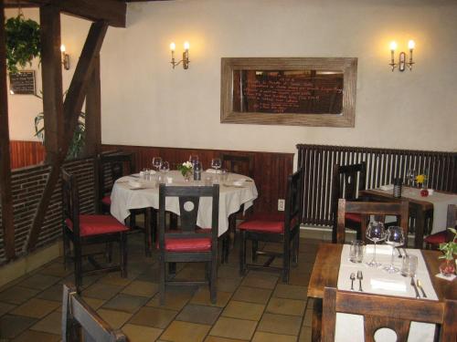 a dining room with tables and chairs in a restaurant at Logis Hotel Restaurant Le Cheval Blanc in Charny