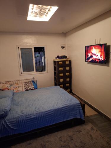 a bedroom with a bed and a tv on the wall at La Pause Dar Bouazza in Tamaris