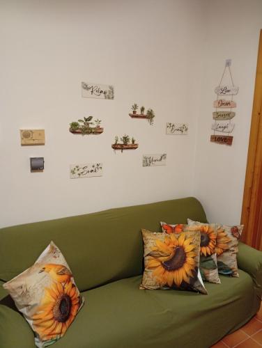 a green couch with two pillows on it in a room at Sunflower in Tavarone
