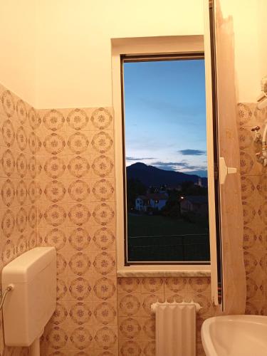 a bathroom with a window and a toilet and a sink at Sunflower in Tavarone