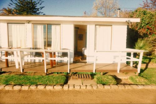 a small white house with a large deck at Hotel Puerto Mayor in San Antonio