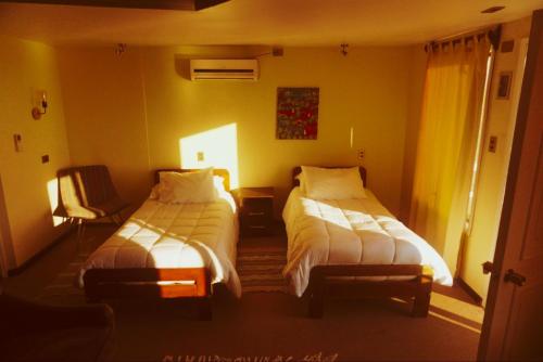 a hotel room with two beds and a window at Hotel Puerto Mayor in San Antonio