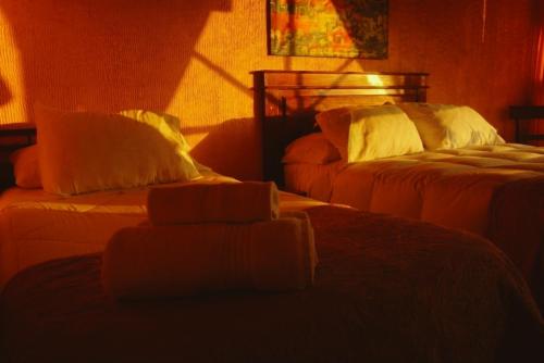 a bedroom with two beds with white pillows at Hotel Puerto Mayor in San Antonio