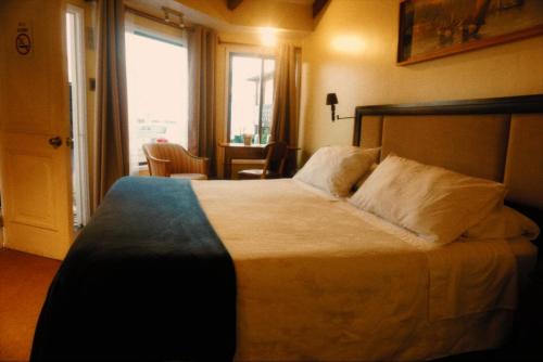 a bedroom with a large bed and a window at Hotel Puerto Mayor in San Antonio