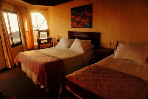 a hotel room with two beds and a window at Hotel Puerto Mayor in San Antonio