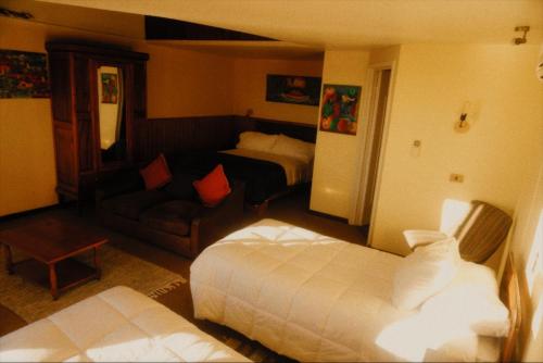 a hotel room with two beds and a couch at Hotel Puerto Mayor in San Antonio