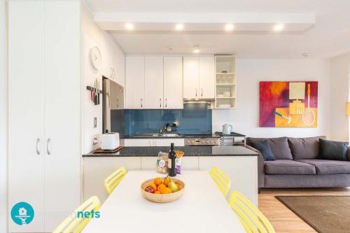 a kitchen with a table with a bowl of fruit on it at Light Filled 1BR Retreat with Car Park & Pool in Sydney