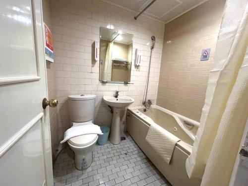 a bathroom with a toilet and a sink and a tub at 柜富賓王旅店-台北館 Giant Rich King Plaza Hotel in Taipei