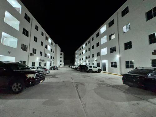 a parking lot with cars parked in front of buildings at DEPARTAMENTO ARRECIFES PLAYA MIRAMAr in Madero