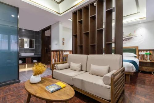 a living room with a couch and a table and a bed at Nost algia Hotel Near University of Technology -Shanxi museum 时光漫步酒店 太原理工大学下元店 Free fresh ground coffee,Free laundry service in Taiyuan