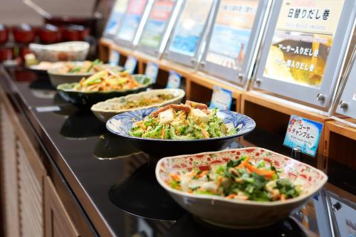 a buffet with bowls of food on a counter at Almont Hotel Naha Kenchomae in Naha
