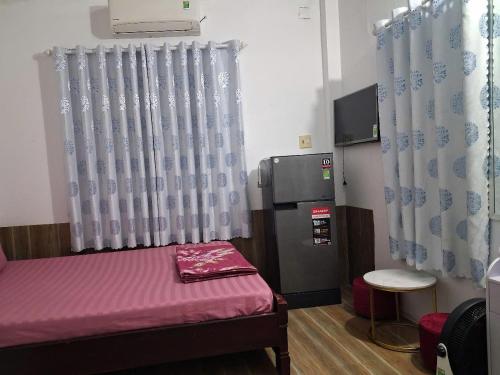 une petite chambre avec un lit et une télévision dans l'établissement O'SEN Homestay, à Phước Hậu (1)