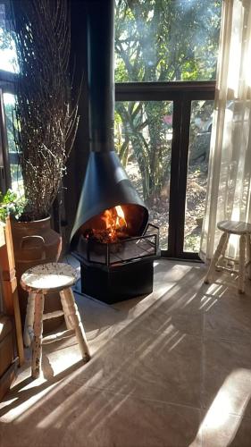 eine Feuerstelle in einem Raum mit einem Fenster in der Unterkunft Sitio João de Barro Gramado in Gramado