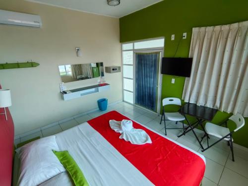 a bedroom with a red and white bed and a desk at Casa Mia in Puerto Escondido