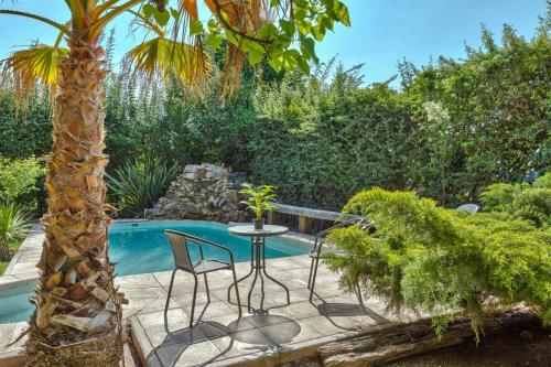 a patio with a table and chairs next to a pool at Fliphaus Alzaga 5100 - 4 Bd House Pool BBQ Daily Housekeeping! in Mendoza