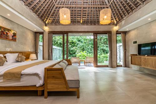 a bedroom with a large bed and a television at Mawar villa Ubud in Ubud