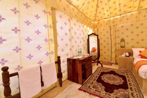 a bedroom with a bed and a mirror at Jaisalmer Sand Dunes Luxury Camp And Resort in Jaisalmer