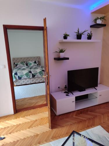 a mirror reflection of a bedroom with a bed and a television at Apartman Stay 23 in Smederevo