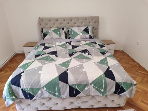 a bed with a black and white comforter and pillows at Apartman Stay 23 in Smederevo