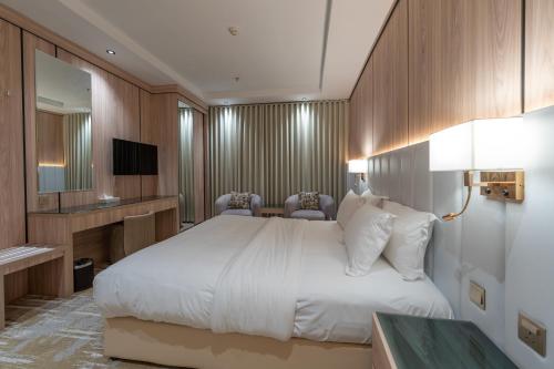 a hotel room with a bed and a television at السهم الذهبي للشقق المخدومة in Taif