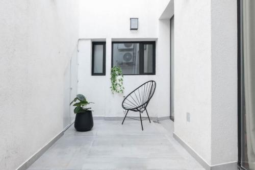 a chair on a porch with a potted plant at Fliphaus Libertador 6300 - RiverPlate Stadium A in Buenos Aires
