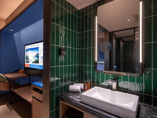 a bathroom with a sink and a mirror at Orange Hotel Beijing Shangdi Anningzhuang in Beijing
