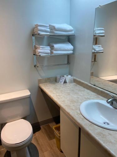 a bathroom with a sink and a toilet and towels at Moby Dick Inn in Prince Rupert